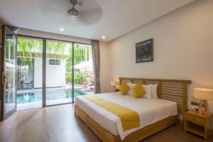 a bedroom with a bed and a swimming pool at MaiChi Villa Hoi An in Hoi An