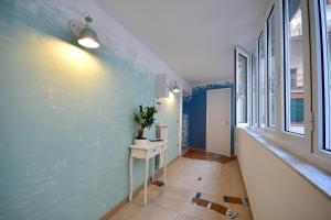 un corridoio con parete blu e tavolo con pianta di Di affreschi e volte a Napoli Altre 25 foto