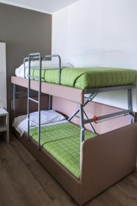 2 Etagenbetten in einem Zimmer mit grüner Bettwäsche in der Unterkunft Albergo Ristorante Belvedere in Tricesimo