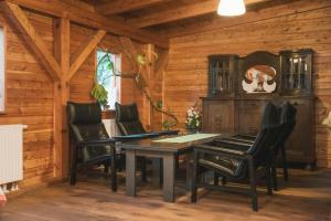 a dining room with a table and black chairs at Agroturystyka Pod Modrzewiami in Nowy Tomyśl