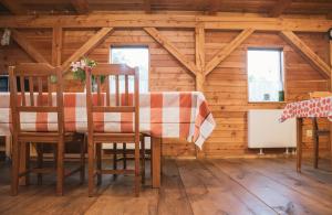 a dining room with a table and chairs in a cabin at Agroturystyka Pod Modrzewiami in Nowy Tomyśl