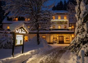 ein Haus mit Schnee in der Nacht in der Unterkunft Waldgasthof & Hotel Am Sauwald in Tannenberg