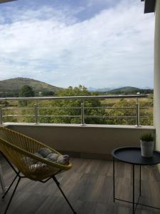 a chair and a table on a balcony with a view at Apartment Doma in Međugorje