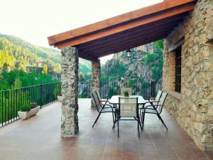 patio con mesa y sillas en el balcón en Casas Rurales Mirador del Rio Zumeta, en Santiago de la Espada