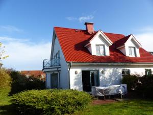 ein weißes Haus mit rotem Dach in der Unterkunft Haus Isabella in Boltenhagen
