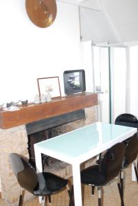einen weißen Tisch und Stühle vor dem Kamin in der Unterkunft Studio le Sterne in Perros-Guirec