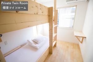 a bunk bed in a room with a window at IZA Enoshima Guest House and Bar in Fujisawa