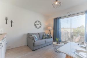 a living room with a couch and a large window at T2 4pers royan centre proche marché / 10mn plage in Royan