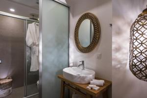 
a bathroom with a sink, mirror, and shower stall at Omiros Boutique Hotel (Adults Only) in Rethymno Town
