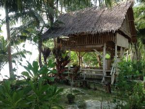 a bamboo house with a thatched roof in a forest at Masokut Surf Camp Siberut E"bay 1 minute walking Beng-Beng 5 minute walking,Pitstop 10 minute walking nipussy 1 hour walking short walking only minute distances from our place in Masokut