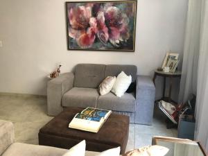 uma sala de estar com um sofá e uma mesa em Bilingual Home em Belo Horizonte