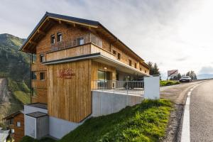uma casa de madeira ao lado de uma estrada em Landhaus Bergblicksuite TOP11 em Damüls