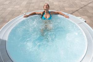 uma mulher está numa piscina em Botrona B&B em Scarlino