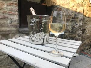 a glass of wine sitting on a table with a bucket at Serenity in Piegaro
