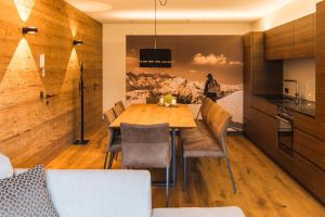 uma cozinha e sala de jantar com uma mesa de madeira e cadeiras em Landhaus Bergblicksuite TOP11 em Damüls