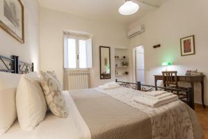 Datini Apartment في براتو: غرفة نوم بسرير كبير عليها شراشف ووسائد بيضاء