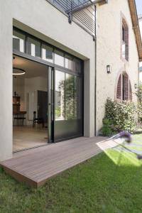 a sliding glass door of a house with a yard at Les Apparts de Marin in Laval