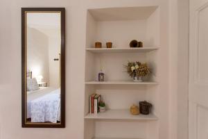 Datini Apartment في براتو: مرآة على جدار بجوار غرفة النوم