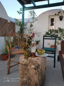 uma garrafa de vinho sentada numa pedra ao lado de uma cadeira em L'artisan em Harqalah
