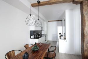 kuchnia i jadalnia z drewnianym stołem i krzesłami w obiekcie SunSet Bastian Apartment w mieście San Sebastián