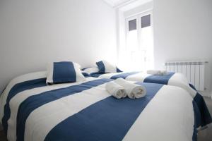 dwa łóżka z ręcznikami na górze w sypialni w obiekcie SunSet Bastian Apartment w mieście San Sebastián