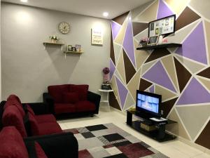 a living room with a couch and a tv at D'Q Putra Homestay Melaka Unit MIQA in Melaka
