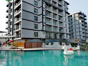 a swan in a swimming pool in front of a building at The Iconic Hotel Suvarnbhumi Airport in Ban Khlong Chorakhe