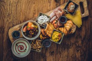 a tray of breakfast foods on a wooden table at Hotel Colonie 7 in Merksplas
