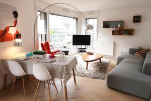 sala de estar con mesa y sofá en Chambre d'hôte Naos Homestay, en Boulogne-Billancourt