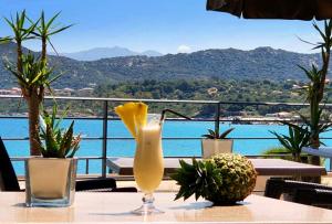 un vase sur une table avec vue sur l'eau dans l'établissement Perla Rossa, à LʼÎle-Rousse