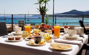 a table with breakfast food on it with a view of the ocean at Perla Rossa in LʼÎle-Rousse