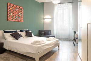 1 dormitorio con 1 cama blanca grande y 1 silla en B&B Mazzini15 en Novara