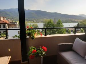 een balkon met een bank en uitzicht op het water bij Studio- apartament Lake View Pravets Golf Resort in Pravets