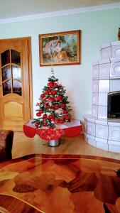 a christmas tree in a living room with a fireplace at APARTMA AJDA in Komenda