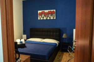 a bedroom with a bed with a blue wall at Hotel Kennedy in Naples