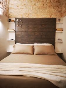 a bedroom with a large bed with a wooden headboard at Suite Mazzini con piscina in Ostuni