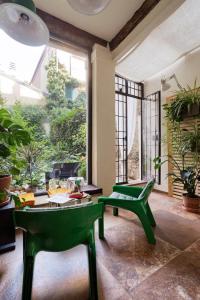 a living room with two green chairs and a table at Giardino Segreto in Bologna