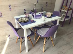 a table with purple chairs and a white table with a plate at Casa Violet per Civita in Bagnoregio