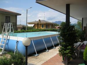 a large swimming pool with a ladder next to a house at La casa dei pini in Malnate