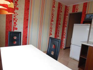 a kitchen with a white refrigerator and red walls at заречанская 57/1 in Khmelʼnytsʼkyy +4 photos