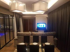 a living room with a couch and a tv at PoolVilla Chaam NL in Cha Am