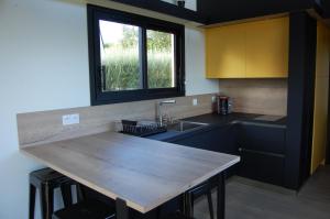a kitchen with a wooden counter top and a sink at Tiny House sur la cote bretonne in Cléder