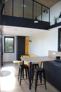 Tiny House sur la cote bretonne في Cléder: مطبخ مع طاولة خشبية كبيرة وكراسي