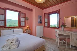 Schlafzimmer mit einem Bett, einem Schreibtisch und Fenstern in der Unterkunft Xani Hotel in Kleidoniá