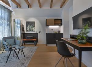a living room with a table and chairs and a kitchen at Konrads Limburg - Hotel & Gästehaus in Limburg an der Lahn