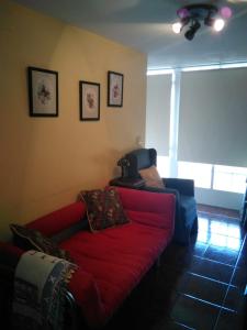 sala de estar con sofá rojo y ventana en Casa Laguiñas en Castro Caldelas en Castro Caldelas