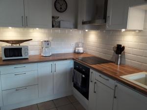 a kitchen with white cabinets and a counter top at Villa BonBon Siwo in Le Diamant