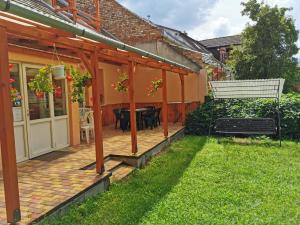 a patio with a table and a bench in a yard at Kis Rigó vendégház in Salgótarján