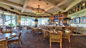 a restaurant with tables and chairs and a bar at GreenLinks Golf View Villa Mustang at Lely Resort in Naples