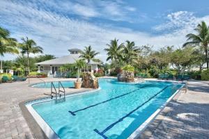 a swimming pool at a resort with palm trees at GreenLinks Golf View Villa Mustang at Lely Resort in Naples